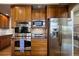 Gourmet kitchen featuring stainless steel appliances, double oven, and a refrigerator at 4373 E Phillips Pl, Centennial, CO 80122