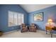 Bright sitting room featuring two chairs, shuttered windows, and blue walls at 4373 E Phillips Pl, Centennial, CO 80122