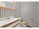 Charming bathroom with striped wallpaper, single vanity and toilet at 9004 E Floyd Ave, Denver, CO 80231