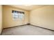 Simple bedroom with carpet flooring, a window, and neutral-toned walls at 9004 E Floyd Ave, Denver, CO 80231