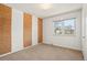 Bright bedroom featuring neutral carpet, white walls, and natural light from a window at 9004 E Floyd Ave, Denver, CO 80231