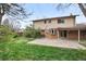 Back exterior view showcasing a spacious yard, patio, and the home's architecture at 9004 E Floyd Ave, Denver, CO 80231