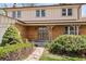 Inviting front entry with brick facade, covered porch and green shrubbery creating a warm welcome at 9004 E Floyd Ave, Denver, CO 80231