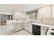Efficient kitchen with white cabinets, black appliances, and neutral countertop at 9004 E Floyd Ave, Denver, CO 80231