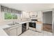 Functional kitchen with white cabinetry, black appliances, and durable tile flooring at 9004 E Floyd Ave, Denver, CO 80231