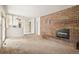 Living room with brick fireplace, carpet, and view into kitchen and hallway at 9004 E Floyd Ave, Denver, CO 80231