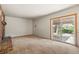 Spacious living room featuring a brick fireplace and sliding glass doors to the outside at 9004 E Floyd Ave, Denver, CO 80231