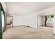 Large living room with neutral carpet and direct access to the staircase and other areas at 9004 E Floyd Ave, Denver, CO 80231