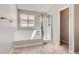 Bathroom with a soaking tub, glass-enclosed shower, and natural light at 2229 Hyacinth Rd, Highlands Ranch, CO 80129