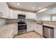 Bright kitchen featuring white cabinetry, stainless appliances, and granite countertops at 2229 Hyacinth Rd, Highlands Ranch, CO 80129
