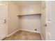 Clean laundry room with tile floors, neutral paint, and a shelf for storage at 2229 Hyacinth Rd, Highlands Ranch, CO 80129