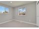 Spacious bedroom with two windows and neutral-colored carpeting at 4750 E Louisiana Ave, Denver, CO 80246