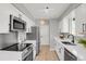 Modern kitchen with white cabinets, stainless steel appliances, and light wood floors at 4750 E Louisiana Ave, Denver, CO 80246