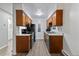 Efficient galley-style kitchen with dark wood cabinets and appliances at 14780 E Kentucky Dr # 414, Aurora, CO 80012