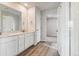 A bathroom with dual sinks, quartz countertops, white cabinets, and a walk-in shower at 4334 Gozzer Ranch Dr, Elizabeth, CO 80107