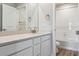 Well-lit bathroom with white vanity, quartz counters, and a shower-tub combo at 4334 Gozzer Ranch Dr, Elizabeth, CO 80107
