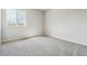 A bedroom with gray carpet and a large window showcasing the landscape at 4334 Gozzer Ranch Dr, Elizabeth, CO 80107