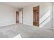 A spacious main bedroom with gray carpet and several doorway entrances at 4334 Gozzer Ranch Dr, Elizabeth, CO 80107
