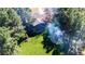 Aerial view of a stunning home nestled among lush trees with a fire pit and expansive yard at 2231 Meadow Green Cir, Franktown, CO 80116