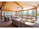 Spacious covered deck with wood ceiling, ceiling fan, outdoor seating, and views of the surrounding forest at 2231 Meadow Green Cir, Franktown, CO 80116