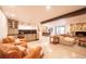 Open-concept living room with stone fireplace and seamless flow to dining area at 2231 Meadow Green Cir, Franktown, CO 80116