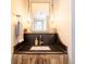 Chic powder room with stone countertop, unique lighting, and wood cabinetry at 2231 Meadow Green Cir, Franktown, CO 80116