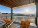 Relaxing outdoor deck with lounge chairs and a beautiful view of the surrounding landscape at 730 Edenborn Pl, Castle Rock, CO 80104