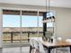 Bright dining area featuring modern chandelier, large windows, and access to a balcony with scenic views at 730 Edenborn Pl, Castle Rock, CO 80104
