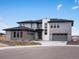 Beautiful modern gray home with a three-car garage, stone accents, and professional landscaping at 730 Edenborn Pl, Castle Rock, CO 80104