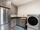 Convenient laundry room featuring modern appliances, custom cabinetry, and sink at 730 Edenborn Pl, Castle Rock, CO 80104