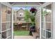 Backyard patio area through French doors with artificial turf, bench, and barbecue grill at 9632 W Chatfield Ave # C, Littleton, CO 80128