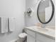 Clean bathroom with modern fixtures, a vanity, and a round mirror at 9632 W Chatfield Ave # C, Littleton, CO 80128