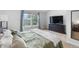 Bright bedroom with a large window, neutral carpet, and a mounted television at 9632 W Chatfield Ave # C, Littleton, CO 80128