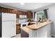 Charming kitchen features wood cabinets, white appliances, and a cozy breakfast bar at 9632 W Chatfield Ave # C, Littleton, CO 80128