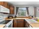 This well-lit kitchen has dark cabinets, stainless steel appliances, and a garden view at 9632 W Chatfield Ave # C, Littleton, CO 80128