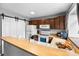 Bright kitchen with wood cabinets, white appliances, and a breakfast bar featuring a sink at 9632 W Chatfield Ave # C, Littleton, CO 80128