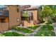 View of a well-maintained condo exterior with green grass, rock path, privacy fence and mature landscaping at 9587 W 89Th Cir, Broomfield, CO 80021