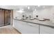 Modern kitchen island with white cabinets and gray countertops, complete with a dishwasher and sink at 9587 W 89Th Cir, Broomfield, CO 80021