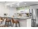 Modern kitchen featuring stainless steel appliances, stylish bar stool seating, and ample counter space at 9587 W 89Th Cir, Broomfield, CO 80021