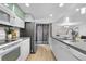 Modern white kitchen with stainless steel appliances and bright lighting featuring outdoor access at 9587 W 89Th Cir, Broomfield, CO 80021