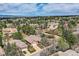Picturesque aerial view of homes with tiled roofs, mature trees, and a view of the Denver skyline at 1 Silver Fox Dr, Greenwood Village, CO 80121