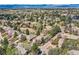 Panoramic aerial view of a verdant, tree-filled neighborhood with stunning mountain views at 1 Silver Fox Dr, Greenwood Village, CO 80121