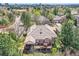 Back of brick home featuring a wooden deck with outdoor seating surrounded by mature trees at 1 Silver Fox Dr, Greenwood Village, CO 80121