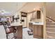 Basement bar area with granite counters, sink, and seating near the staircase at 1 Silver Fox Dr, Greenwood Village, CO 80121