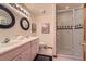 Modern bathroom featuring dual sinks, stylish mirrors, and glass-enclosed shower at 1 Silver Fox Dr, Greenwood Village, CO 80121