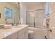 Bright white bathroom featuring tub-shower combo with glass doors, single sink, and tiled countertop at 1 Silver Fox Dr, Greenwood Village, CO 80121