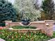 Beautiful community entrance adorned with colorful tulips, a stone wall, and decorative metal artwork at 1 Silver Fox Dr, Greenwood Village, CO 80121