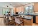 Spacious kitchen with light wood cabinets, black countertops, island with seating, and stainless steel appliances at 1 Silver Fox Dr, Greenwood Village, CO 80121