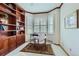 Bright home office with custom built-in shelving and a bay window with plantation shutters at 1 Silver Fox Dr, Greenwood Village, CO 80121