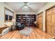 Home office featuring hardwood floors, full wall of built-in shelves, and a ceiling fan at 1 Silver Fox Dr, Greenwood Village, CO 80121